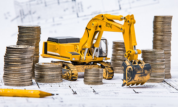 Excavator with money placed on blueprints